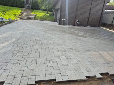 Grey block paving beside a garage